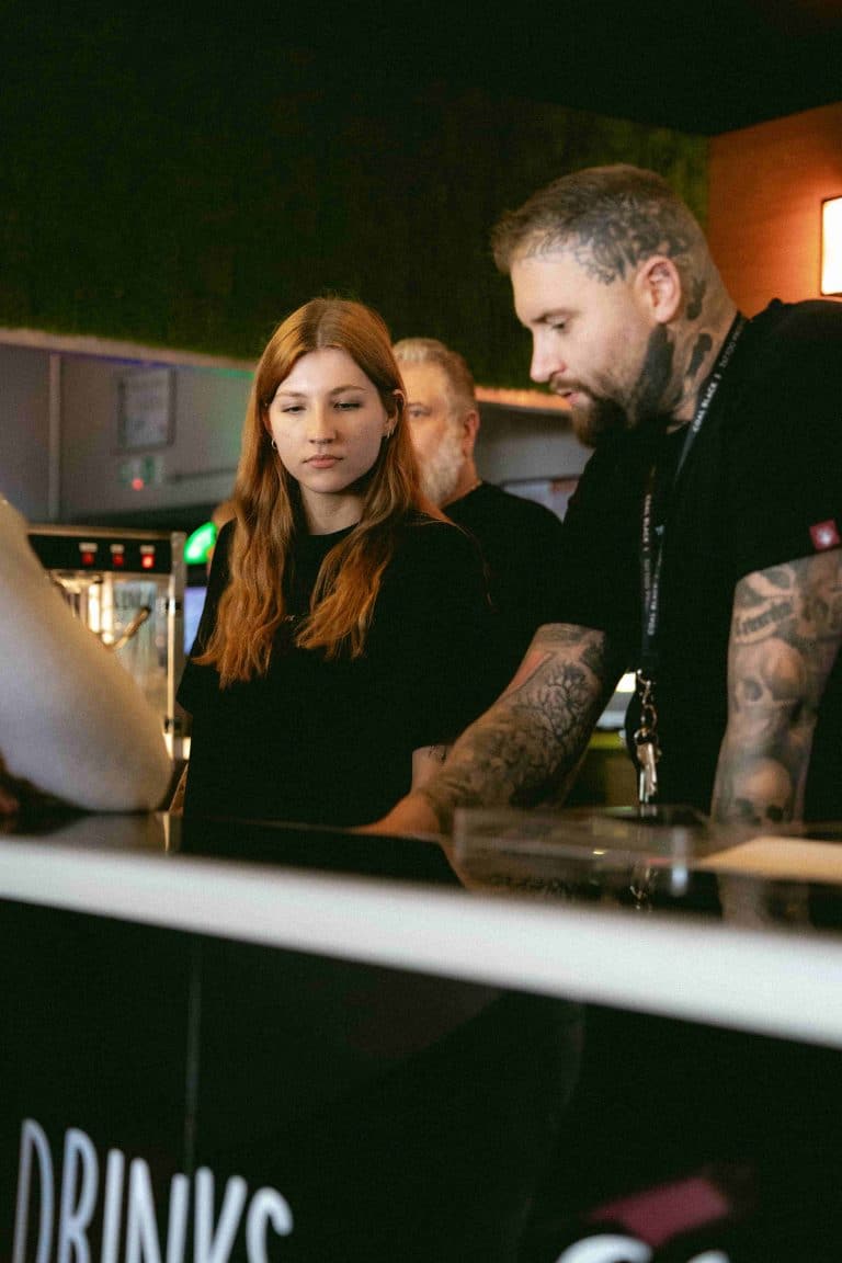 Servicepersonal in der PIKASS Lounge in Ketsch, konzentriert bei der Arbeit an der Bar.