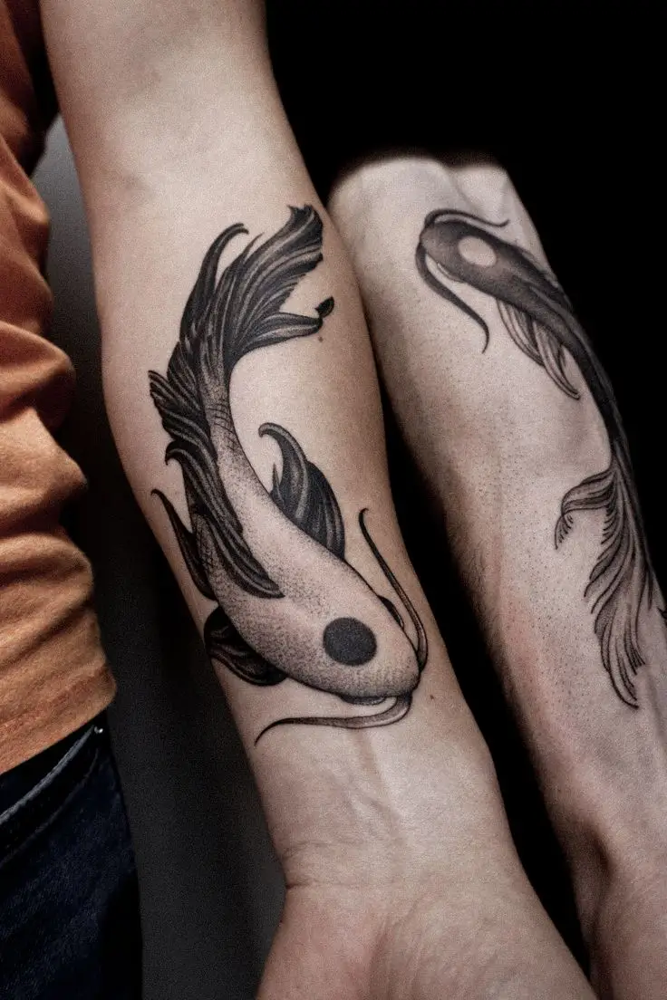 Black and Grey Tattoo auf dem Unterarm mit zwei Koi-Fischen in Yin-Yang-Komposition und Dotwork-Schattierungen