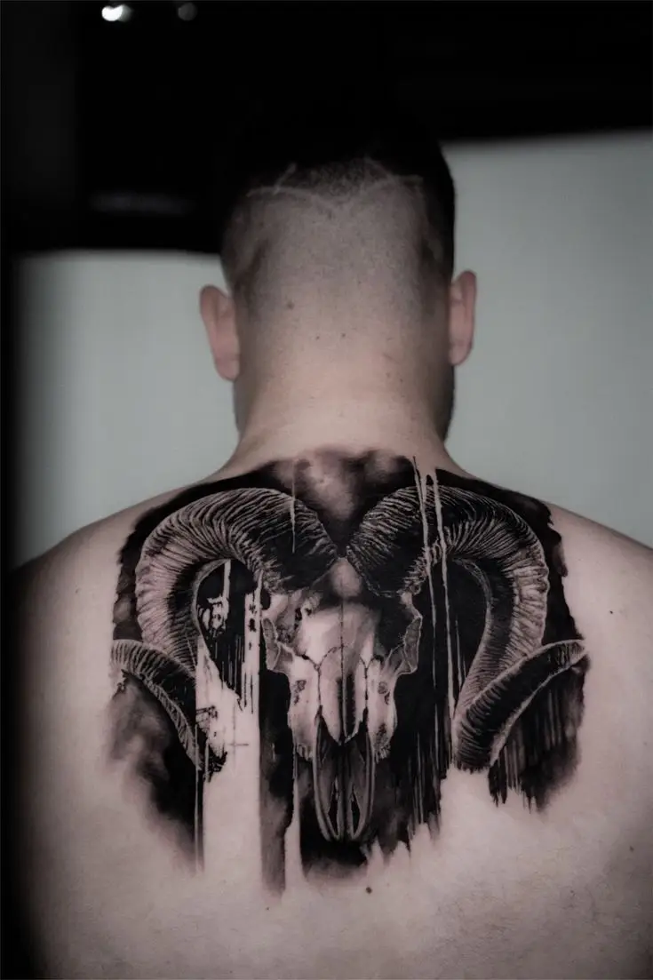 Black and Grey Rücken-Tattoo mit Widder-Schädel, großen Hörnern und dunklen grafischen Schattierungen