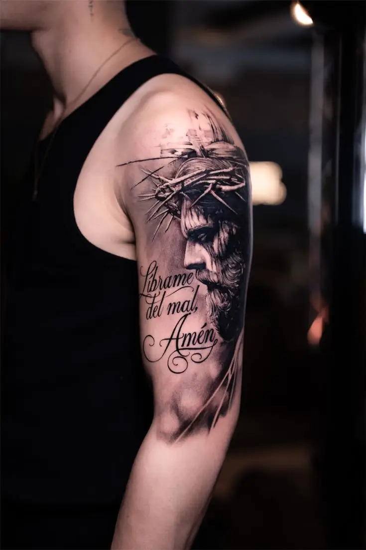 Black and Grey Christus Tattoo mit Dornenkrone und Lettering auf dem Oberarm