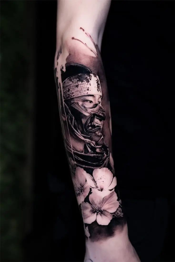 Black and Grey Samurai Tattoo mit Maske und Blumen auf dem Unterarm