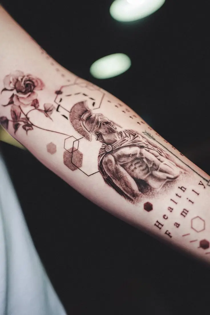 Black and Grey Tattoo auf dem Unterarm mit Spartaner-Motiv, Rose, geometrischen Elementen und Lettering