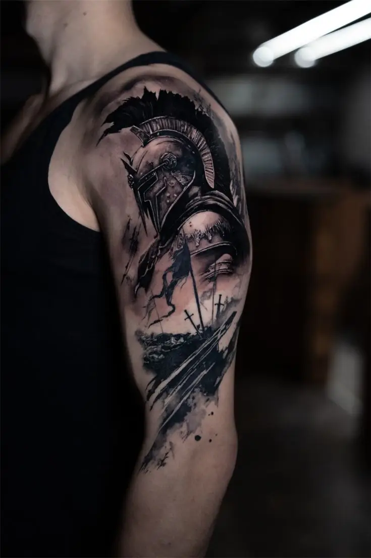 Black and Grey Tattoo am Oberarm mit Spartaner-Helm, Schlachtfeld, Kreuzen und dynamischen Schattierungen