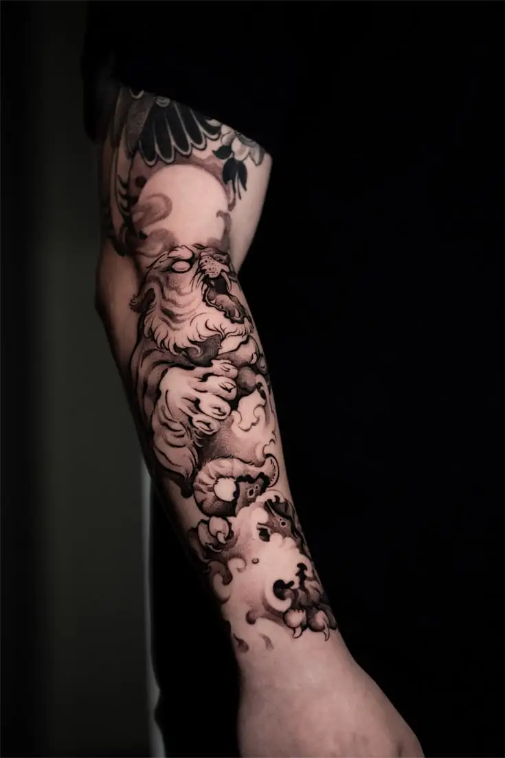Blackwork Tattoo auf dem Unterarm mit japanisch inspiriertem Tiger-Motiv und Wolkenelementen