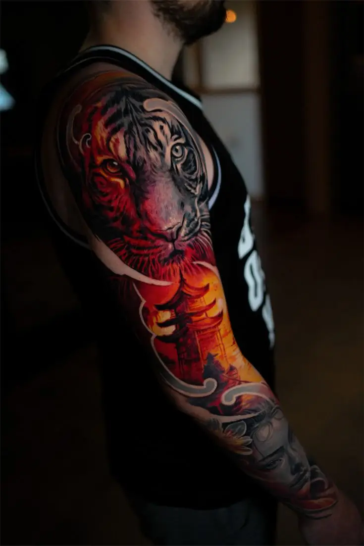 Farbiges Realism Tattoo als Arm-Sleeve mit Tigerkopf, warmen Rot- und Orangetönen und grafischen Details