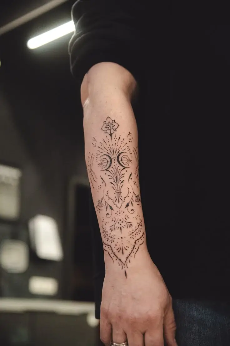 Feines Ornamental Tattoo auf dem Unterarm mit floralen Elementen, Dotwork und symmetrischen Linien
