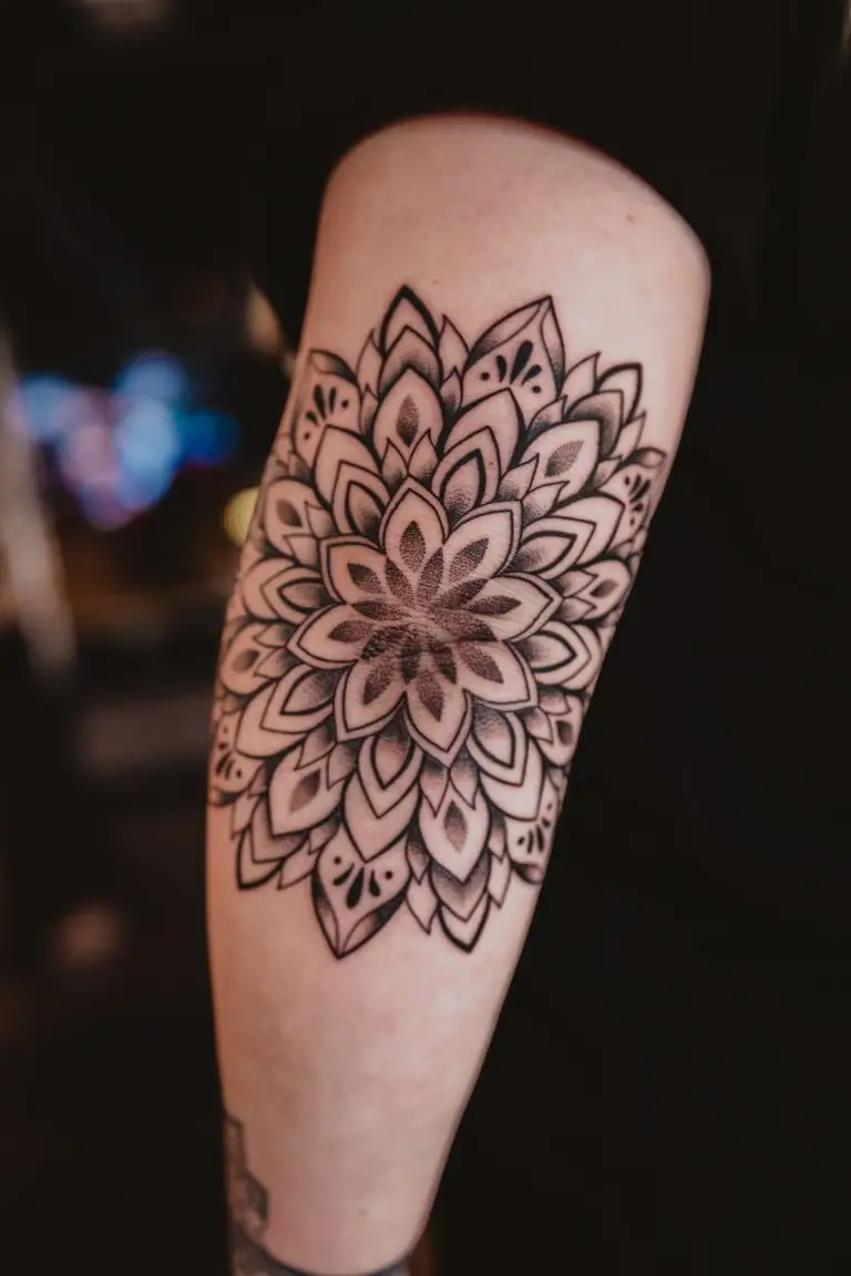 Mandala Tattoo am Oberarm mit symmetrischem Blütenmuster, Dotwork-Schattierungen und klaren Linien