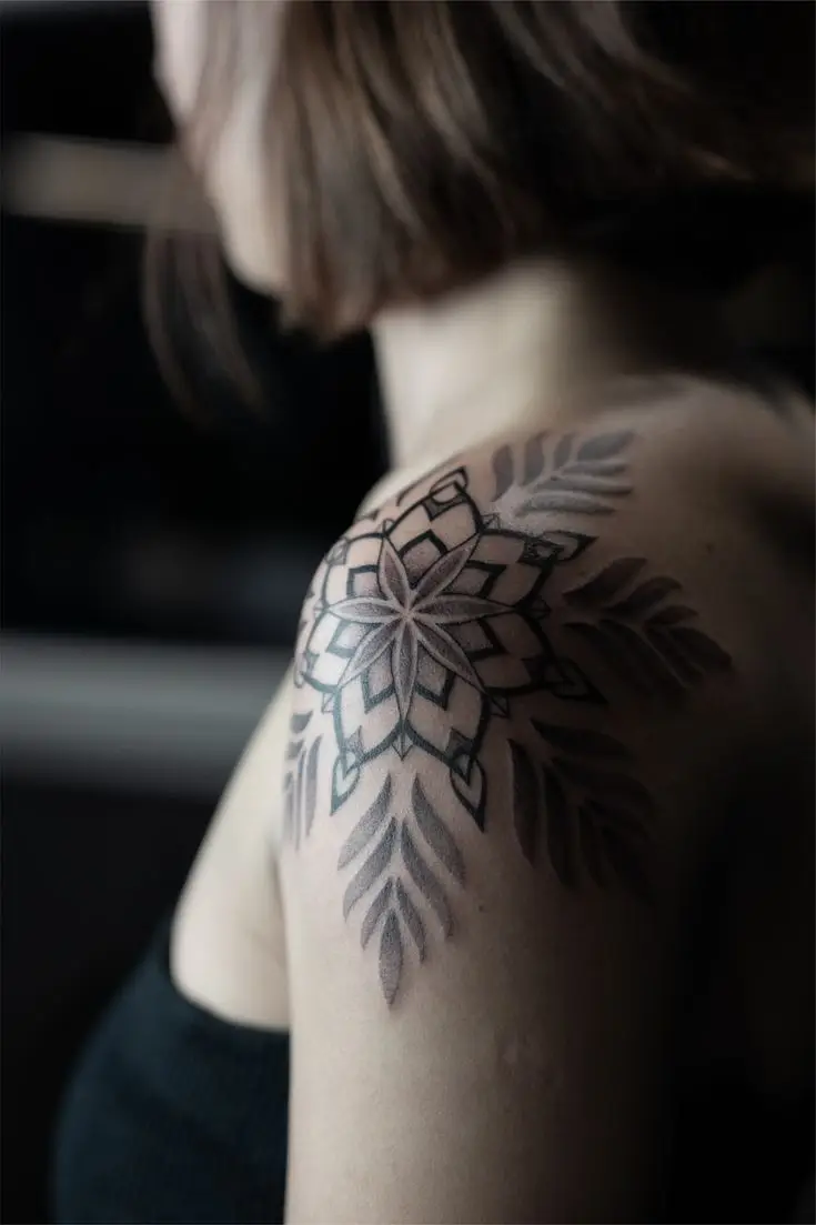 Mandala Tattoo an der Schulter mit symmetrischem Blütenmuster, Dotwork-Schattierungen und ornamentalen Blättern