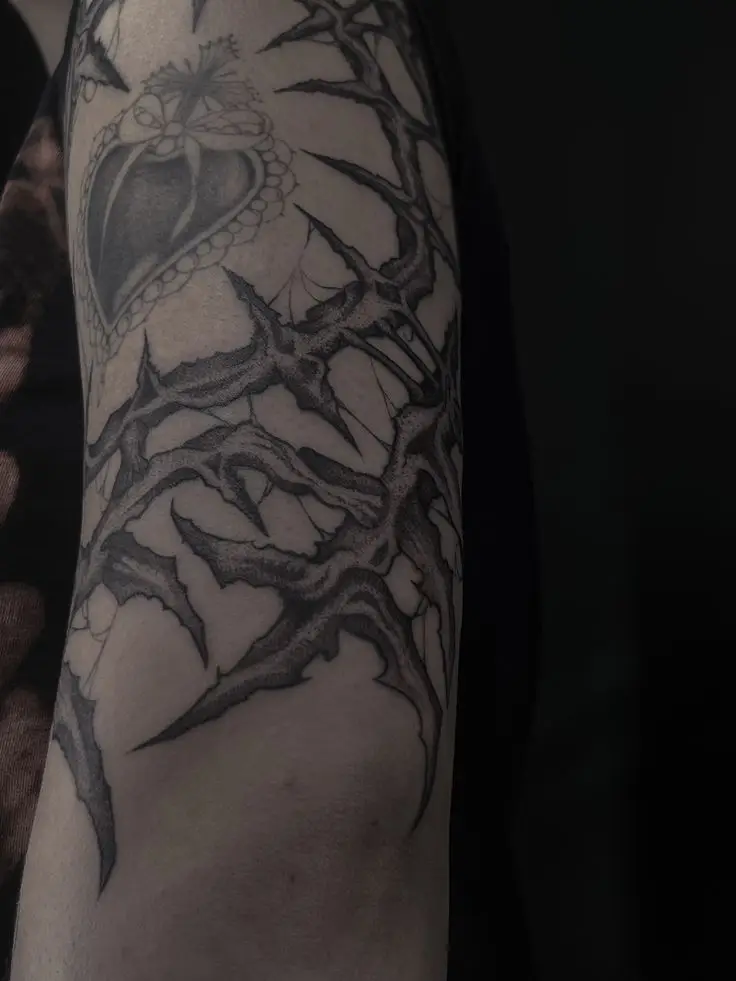 Dark Art Tattoo mit organischen Dornenstrukturen und Black & Grey Schattierungen am Oberarm, gestochen von Manuel bei PIKASS TATTOO.