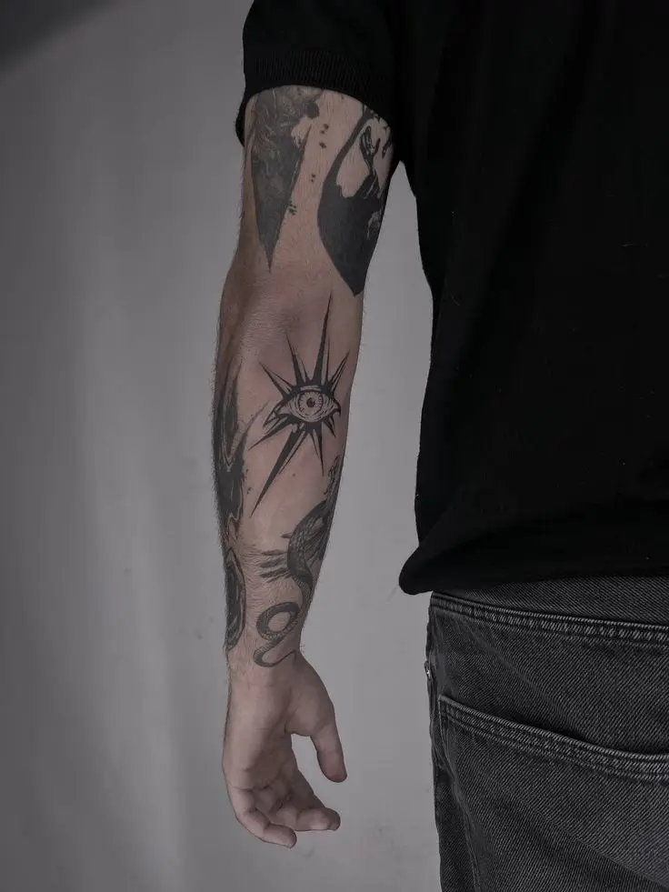 Patchwork Tattoo mit Blackwork Auge und grafischen Elementen am Unterarm, gestochen von Manuel bei PIKASS TATTOO.