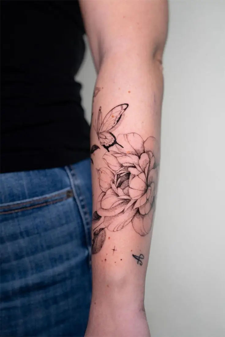 Fineline-Tattoo mit großen Blumen und Schmetterling am Unterarm