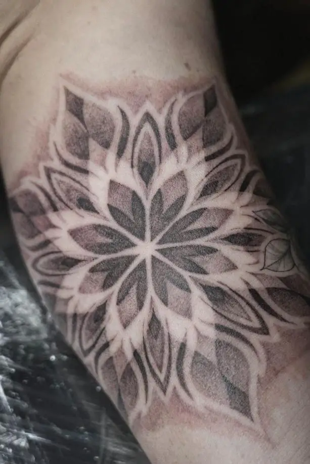 Großes symmetrisches Mandala-Tattoo mit Dotwork-Schattierungen am Oberarm