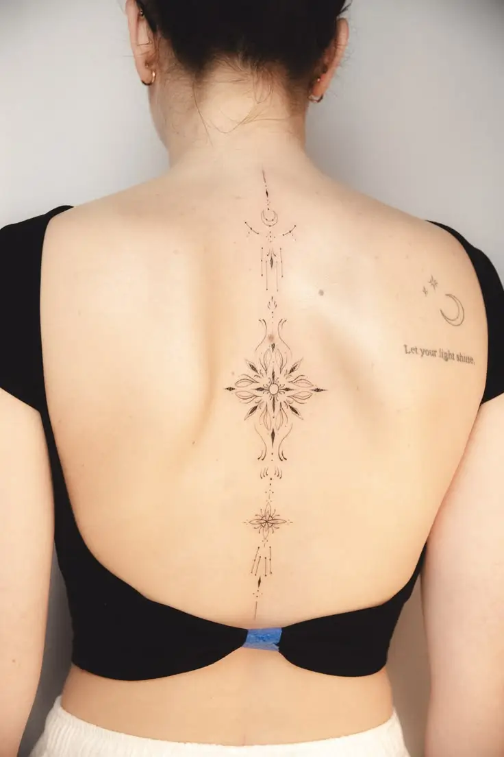 Längliches ornamentales Tattoo mit Mandala-Elementen entlang der Wirbelsäule